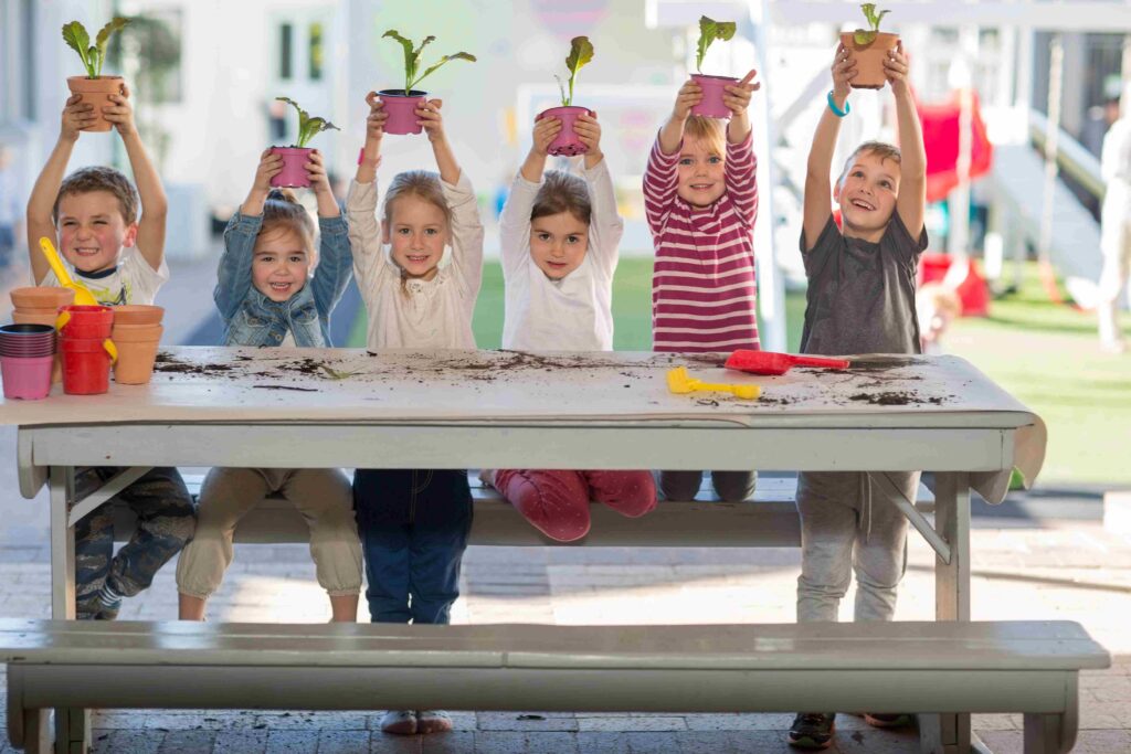 Children proudly holding up their potted plants