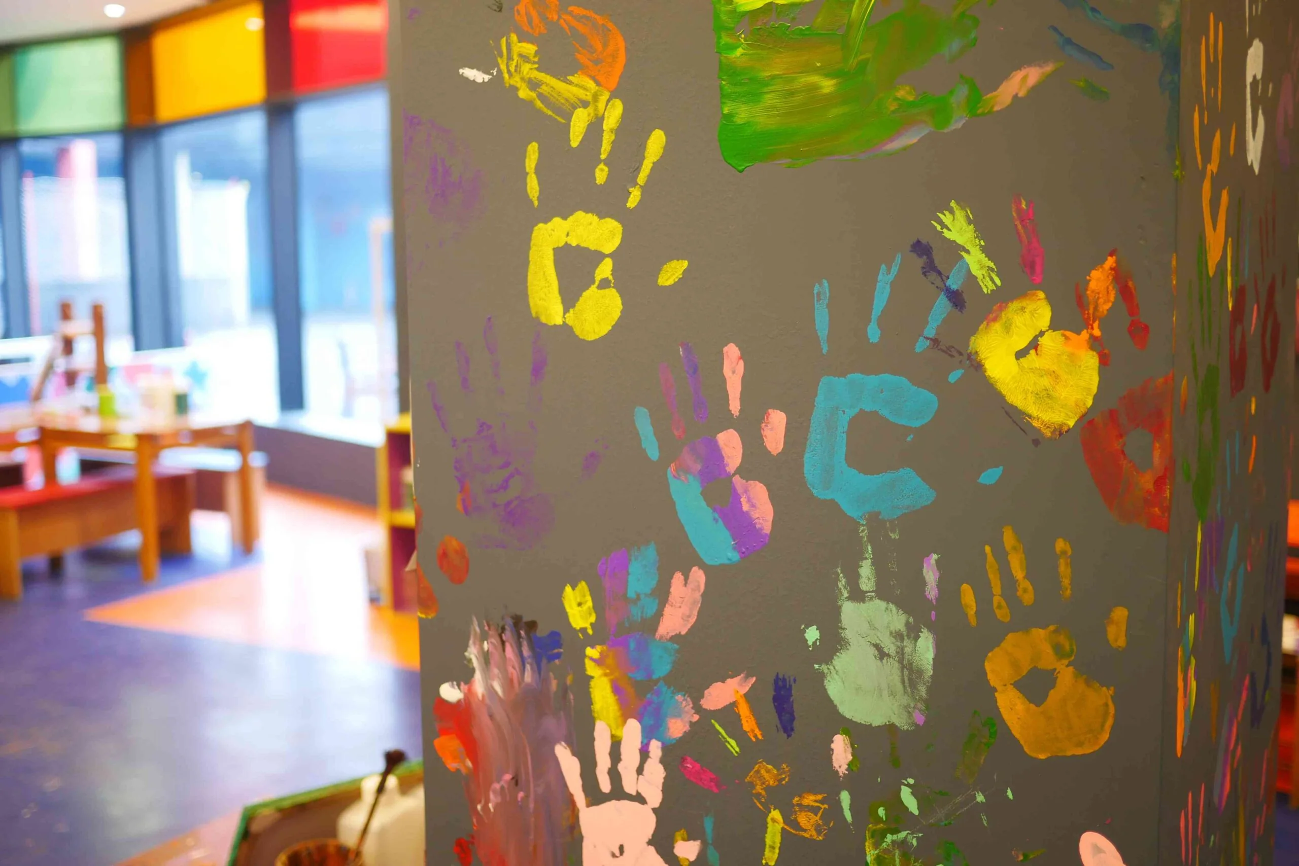 Finger-paint handprints left on the wall by kindergarten students