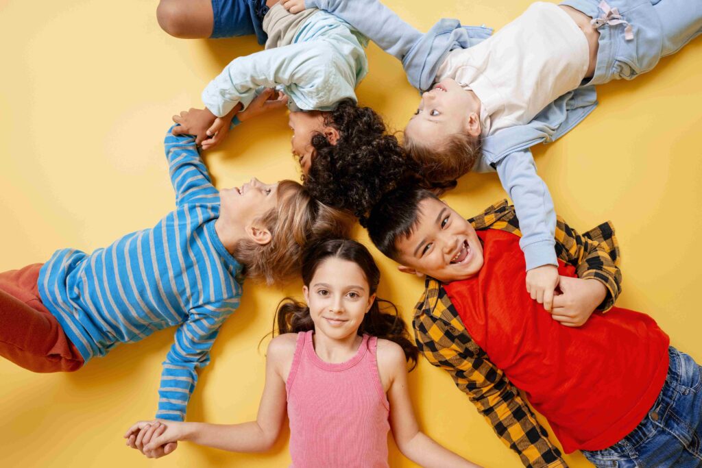 Children lying in a circle, holding hands during a circle activity