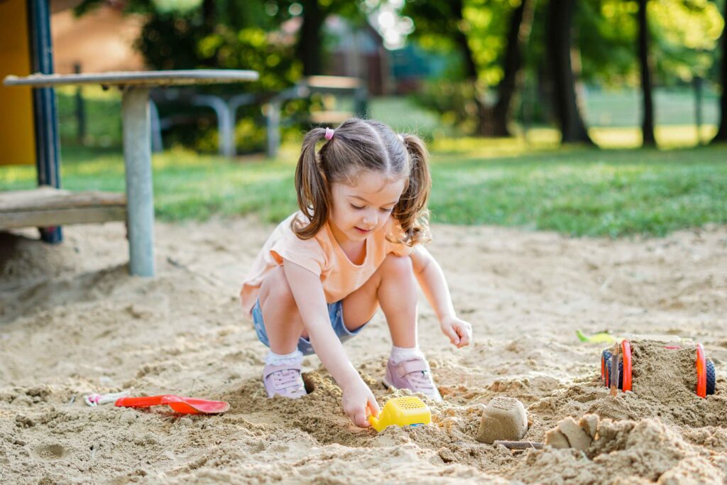 Young girl playing in a sandbox