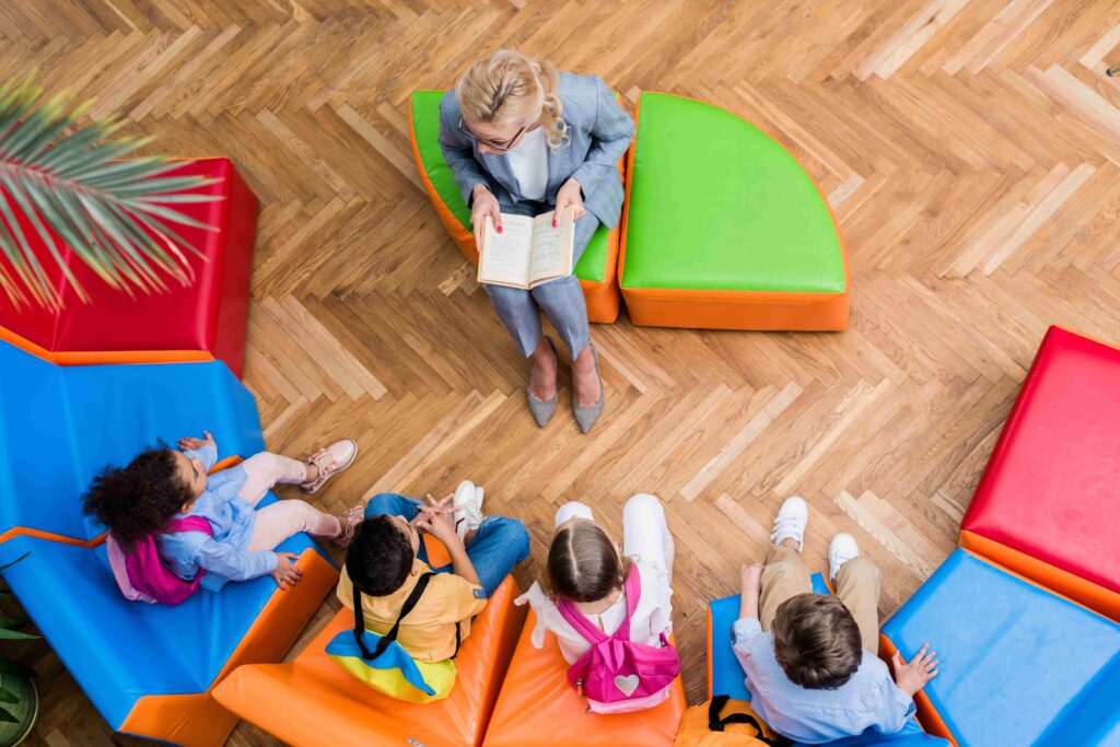 Teacher guiding children with a book