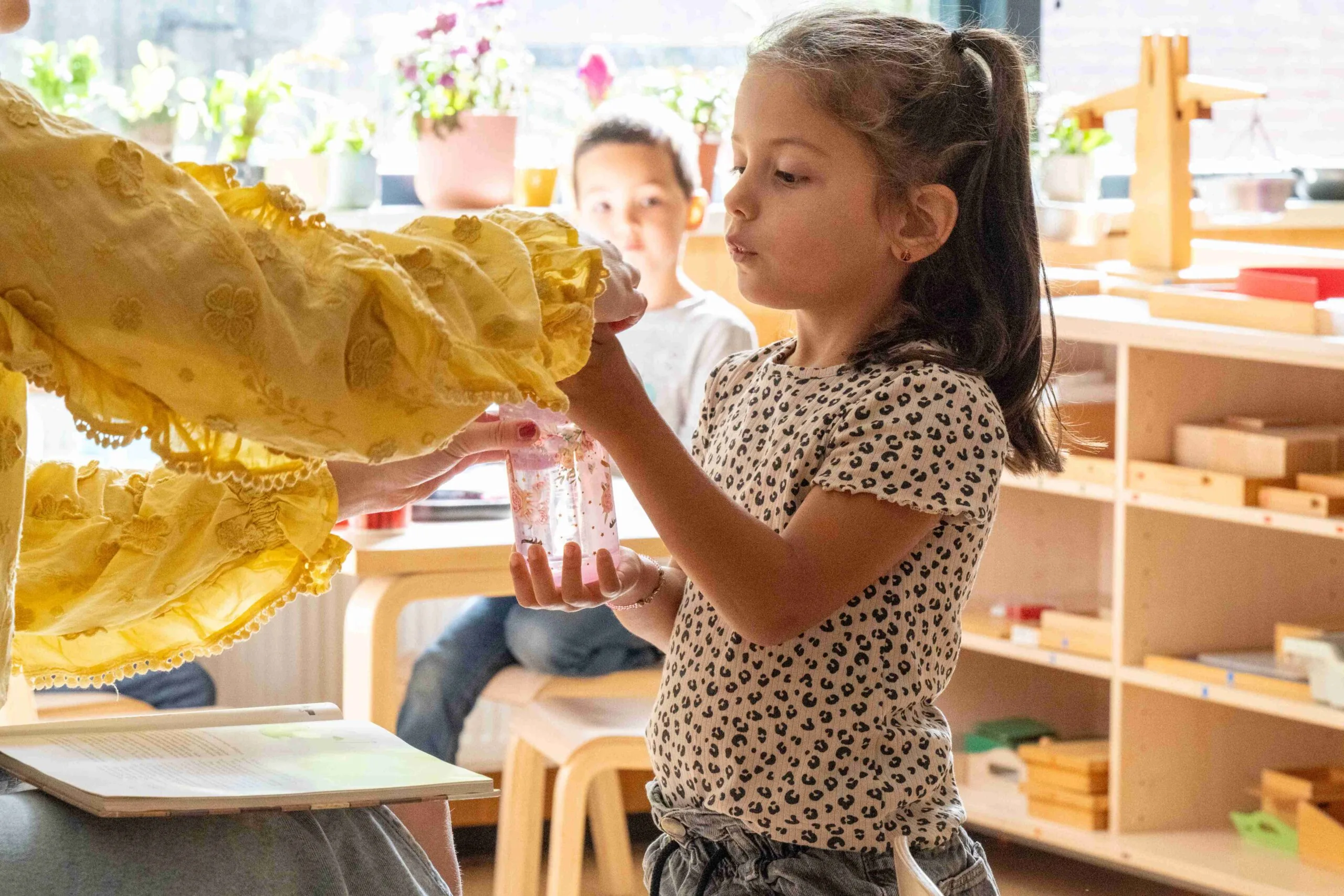 Kindergarten student carefully examining a yellow fabric